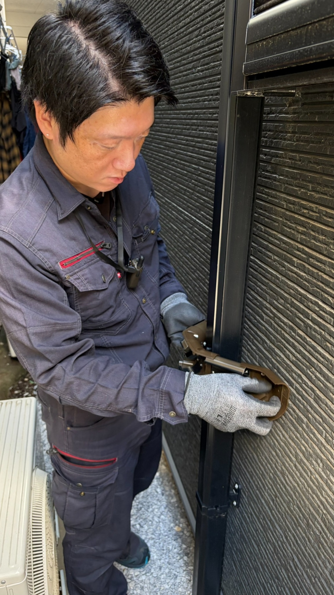 組み上げたダクト部材を竪樋の位置に合わせて確認する職人