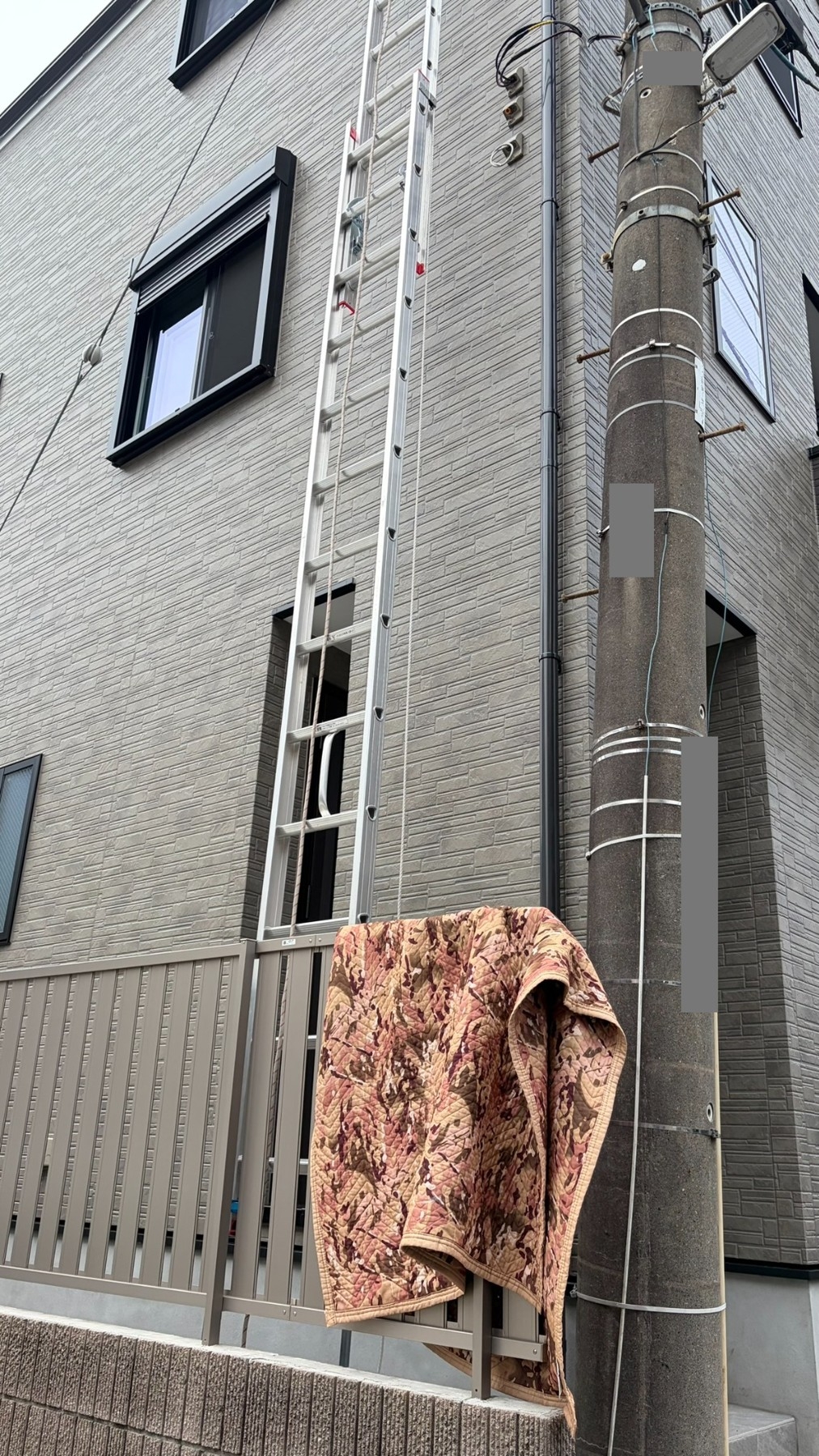 A様宅の高所施工。建物の形状に合わせてハシゴを設置。