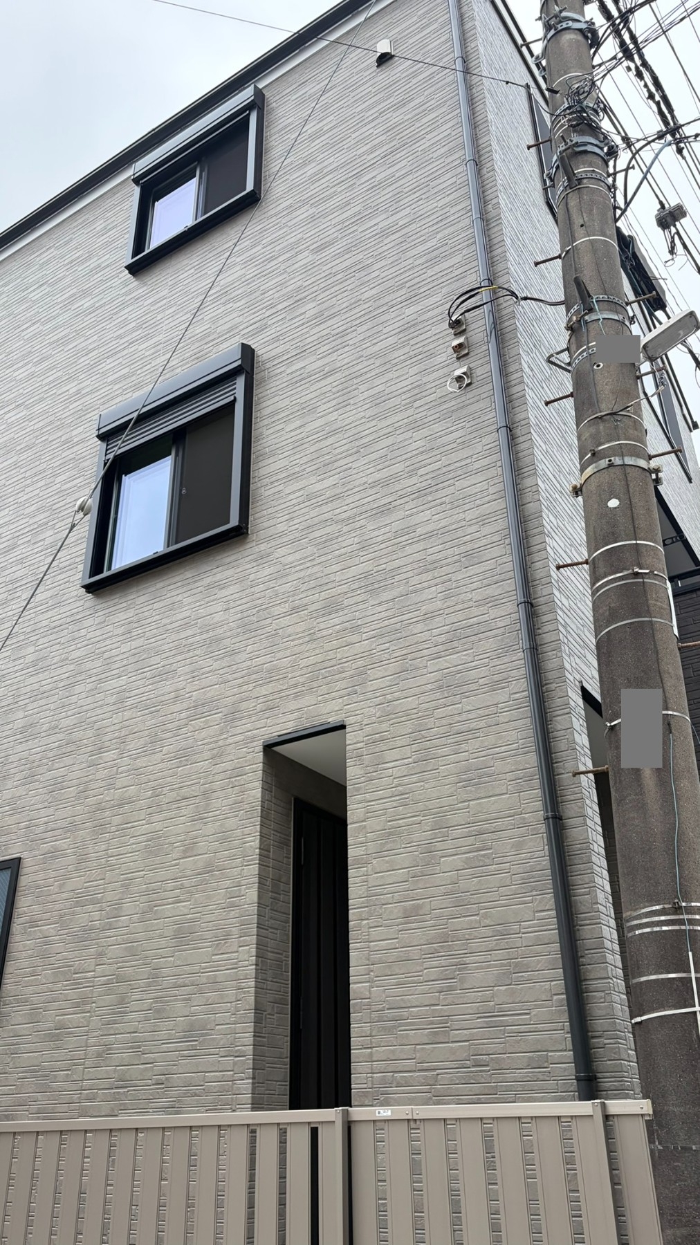 A様宅。新築3階建ての外壁と施工前の設置環境。