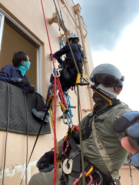 窓まわりを養生し、外壁側と室内側で連携して作業する職人