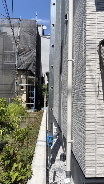 幅約35cmの狭所に敷地内から垂直に設置した高所作業用ハシゴ
