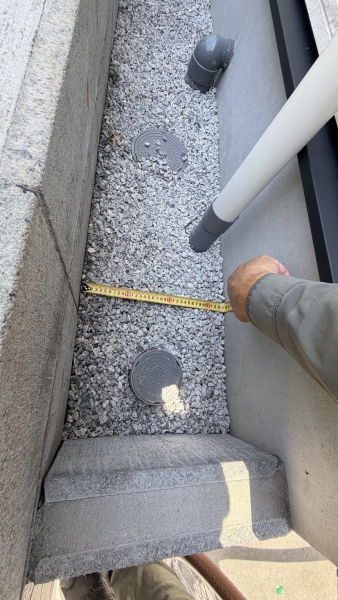 建物と境界ブロックの間が約35cmとなる狭所をメジャーで計測