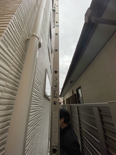 狭所の外壁とフェンスの間に設置した高所作業用ハシゴ
