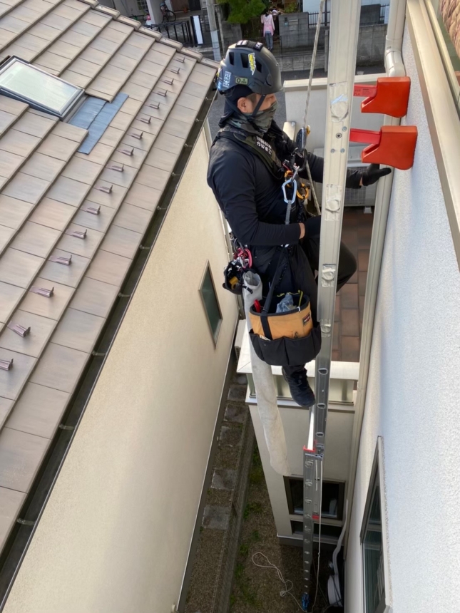 上部の施工位置で壁との距離を整える職人