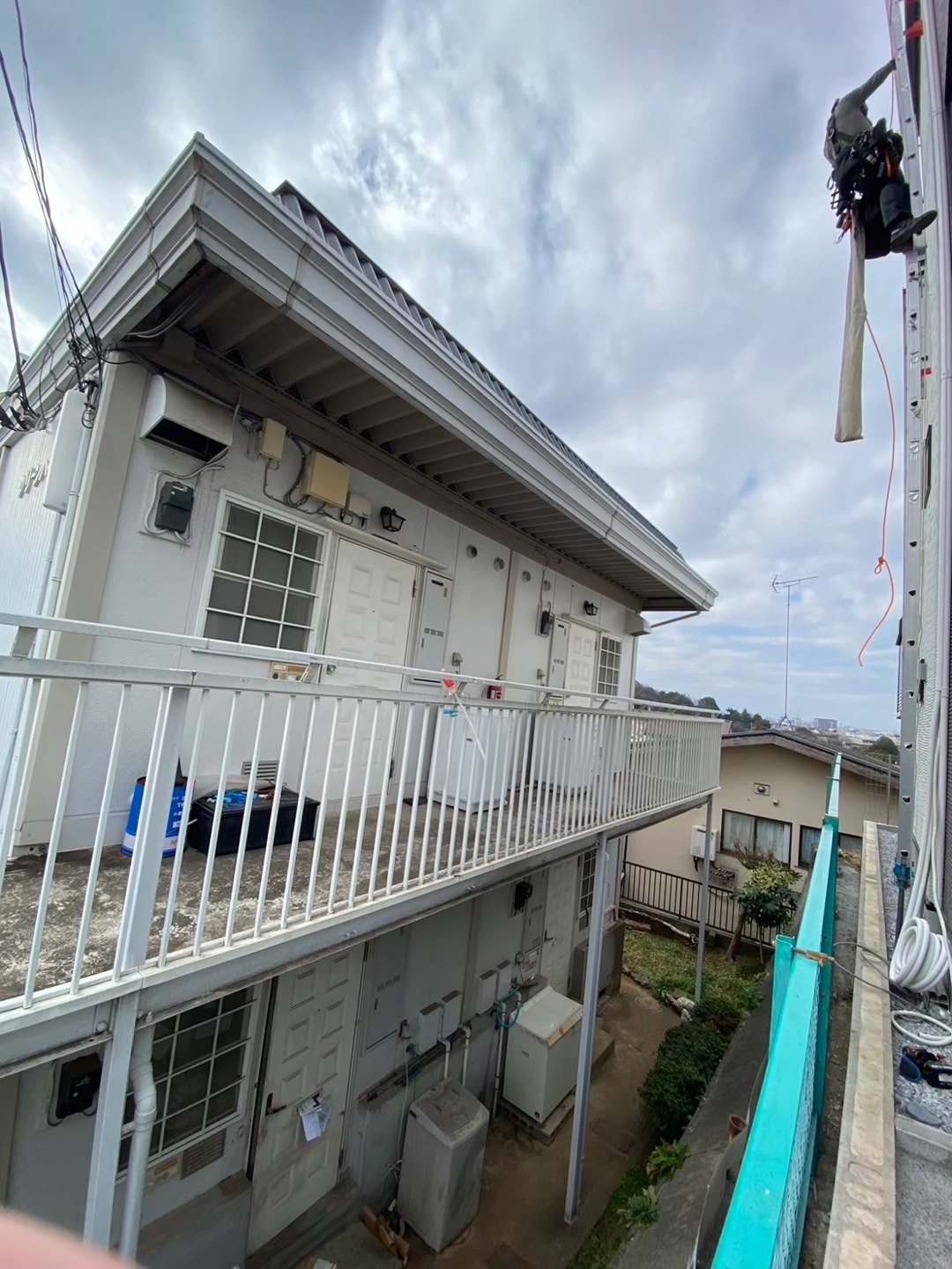 周囲の建物と地面までの高低差が分かる高所作業の全景です。