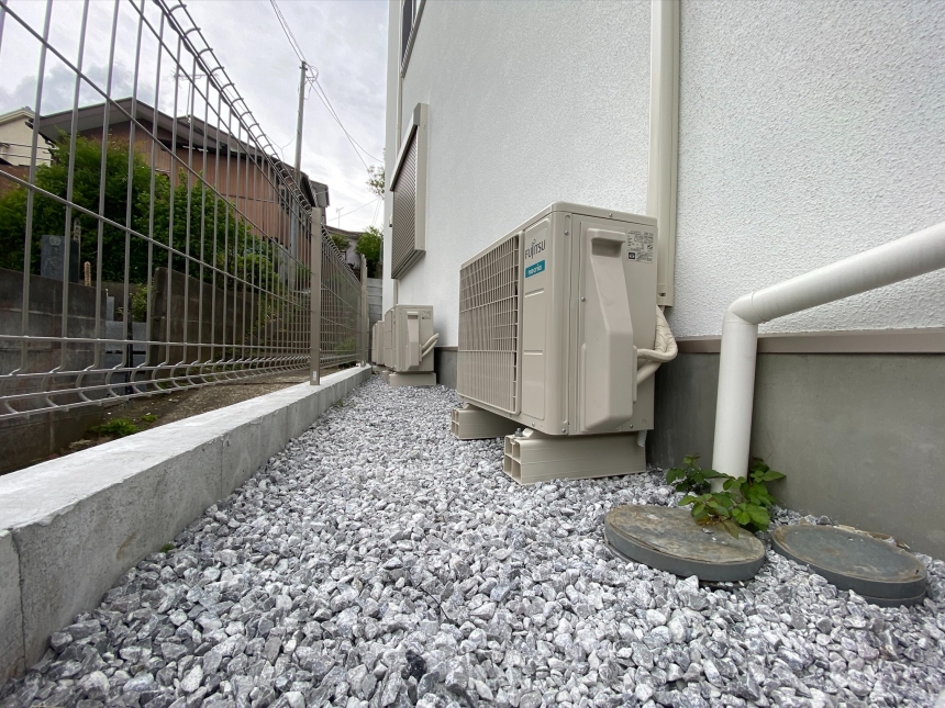 新築住宅の基礎と外壁に沿って納めた室外機と配管の完成詳細