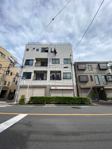建物外壁でロープアクセスによりエアコン工事を行うクアトロテクノサービス