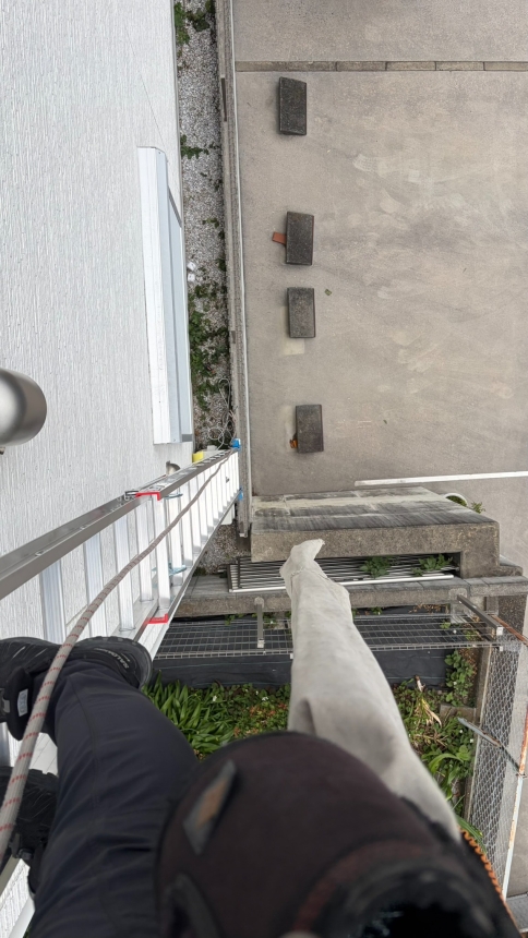 擁壁下までの高さが分かる垂直ハシゴ上からの高所作業風景