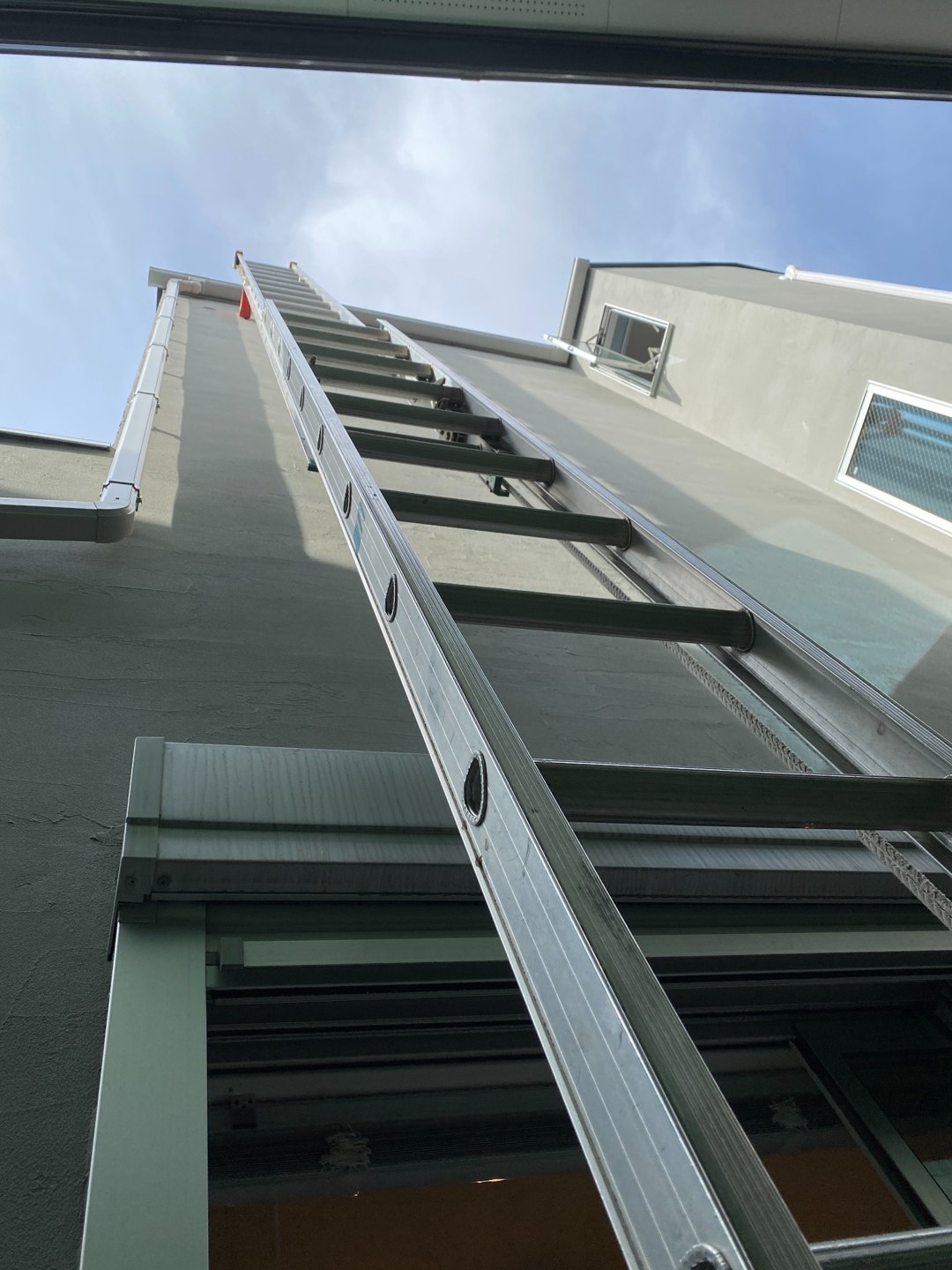 窓の上部から建物上方へ続くハシゴの位置が分かる写真です。