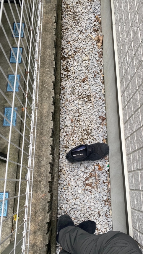住宅の外壁と境界の間に靴を置いて示した靴一足分ほどの狭い足元