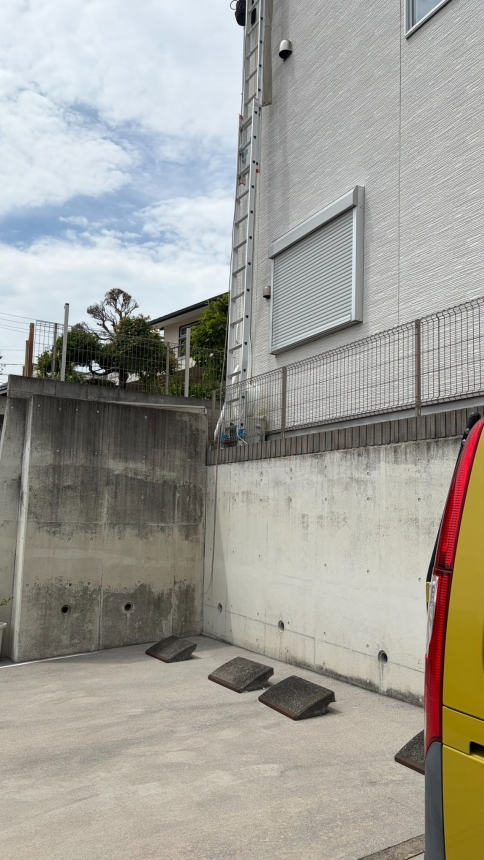 擁壁上の3階建て住宅に設置した高所作業用の垂直ハシゴ