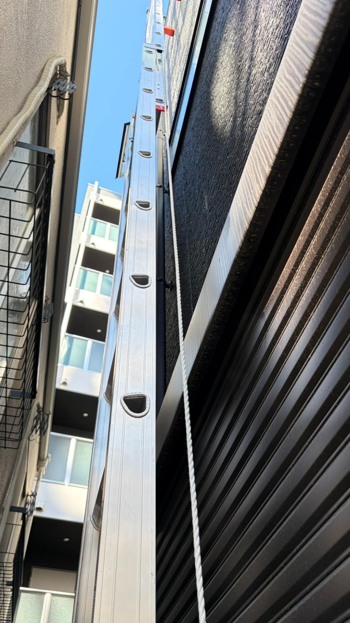 外壁に沿って上方へ伸びる垂直ハシゴ