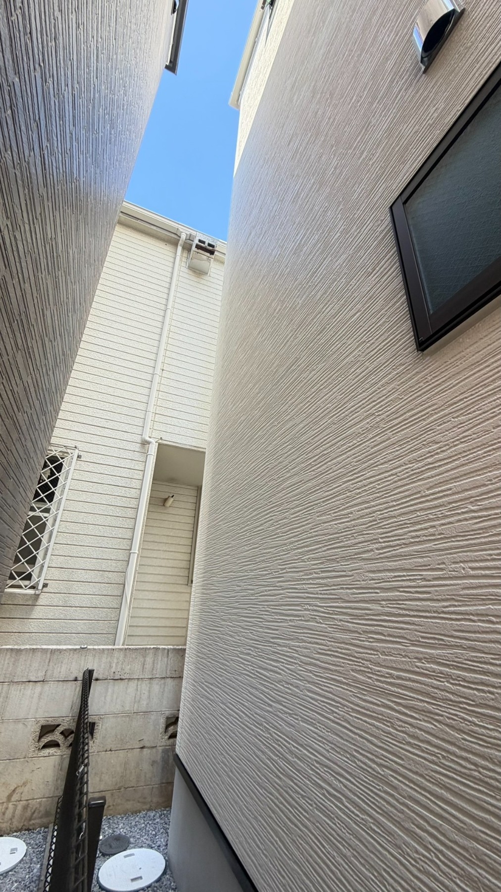 B様宅の建物脇。隣家との間隔や周囲の設備も確認します。