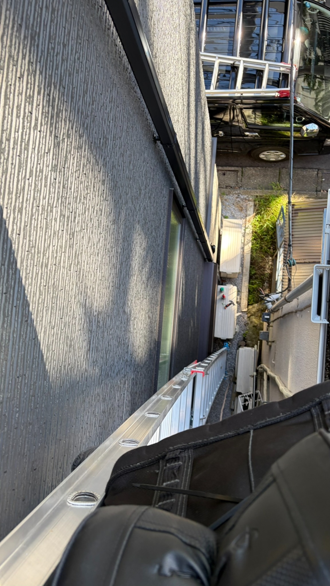 高所の作業位置からハシゴに沿って地上を見下ろした写真