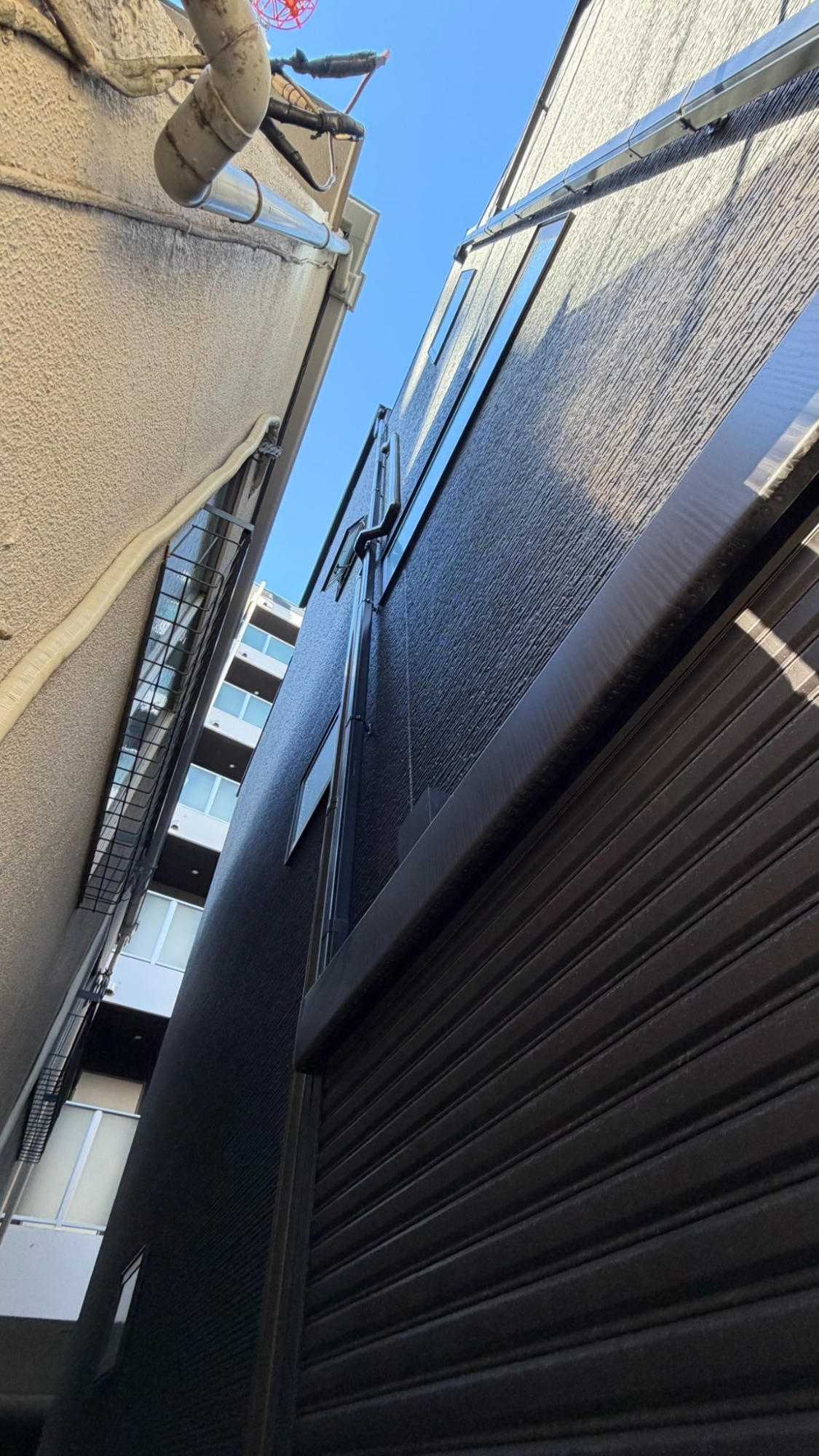 隣接建物の軒や雨樋が近い場所に立てた垂直ハシゴ
