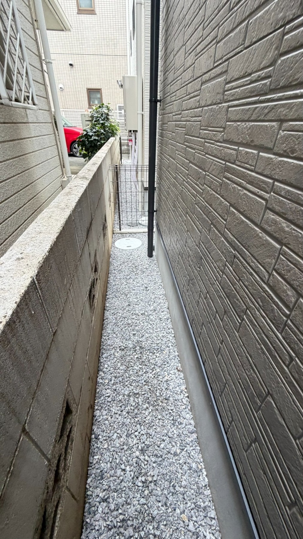 A様宅の建物脇。限られた敷地内で作業方法を検討します。
